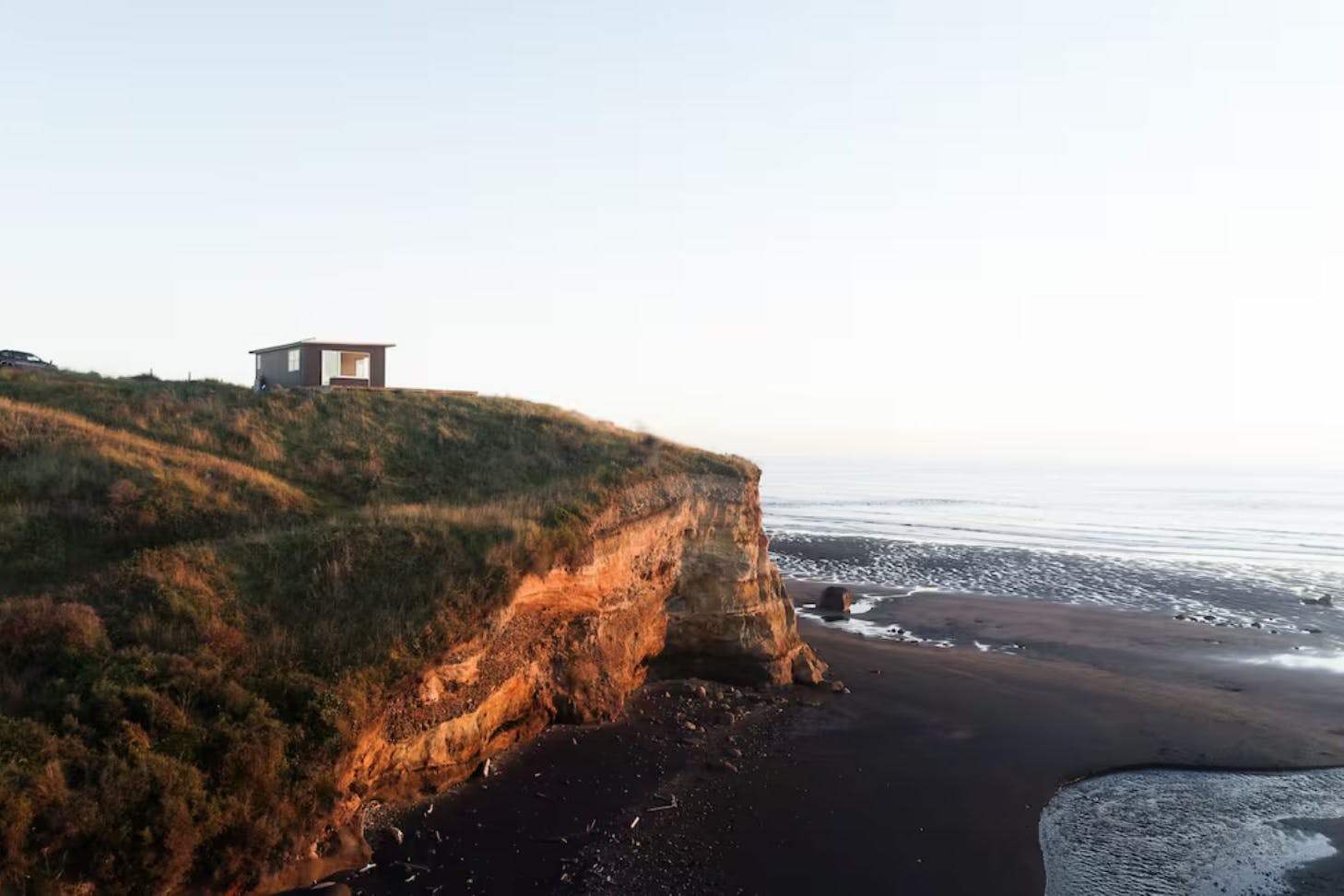 A view of The Nest cosy cabin in New Zealand perched on a cliff top